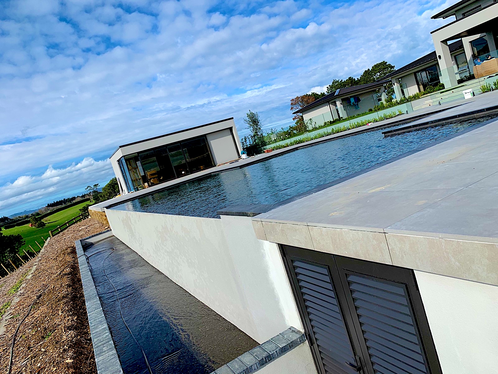 Negative-edge pool with porcelain surround tiled by TZ Tiling